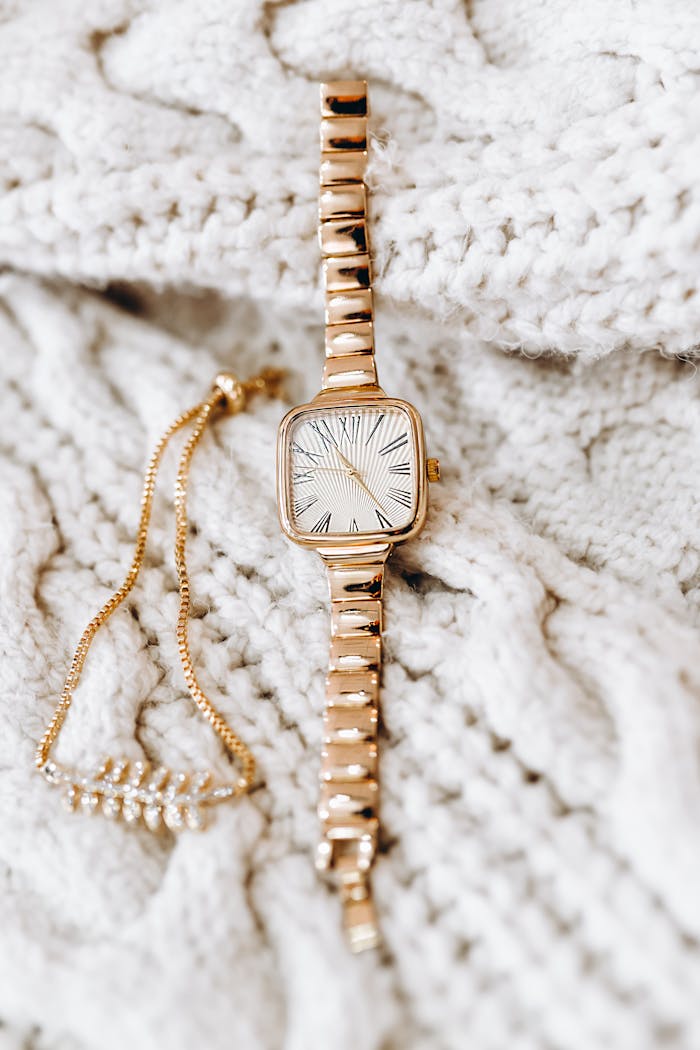 Stylish gold wristwatch displayed on a textured knit blanket, showcasing luxury and timelessness.
